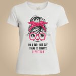 Mistique dizajn majice – djevojka s ružičastom mašnom, naočalama i tekstom "ON A BAD HAIR DAY THERE IS ALWAYS LIPSTICK" – bijela majica.